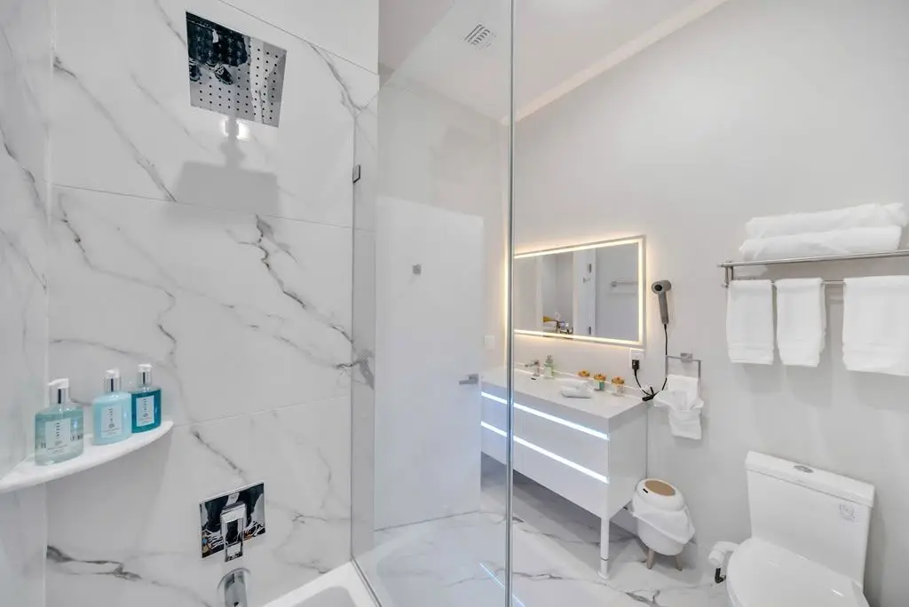 Bathroom with marble-look shower, floating vanity and lit mirror, Residence 304