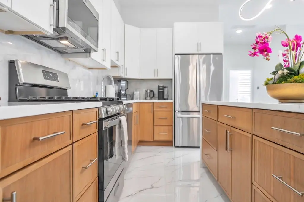 Kitchen with wood-tone cabinets and stainless appliances, Residence 402