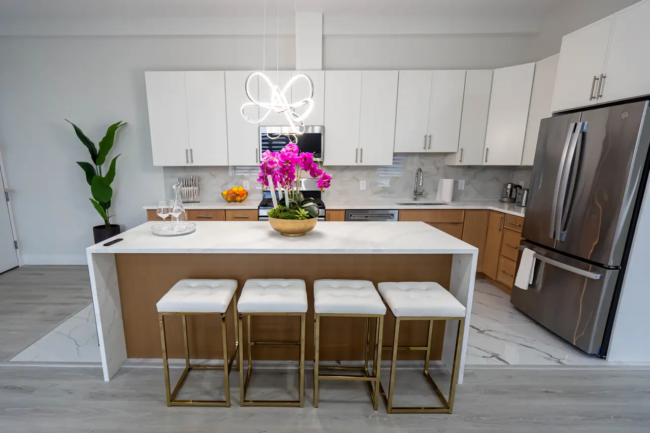 Kitchen with a long marble-topped island and four upholstered stools, Residence 402
