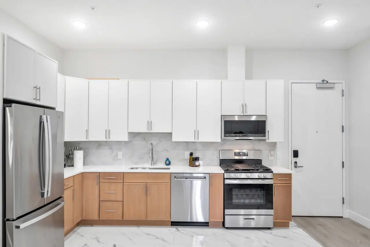 Kitchen with white cabinets, light-wood lower cabinets and stainless appliances, Residence 412