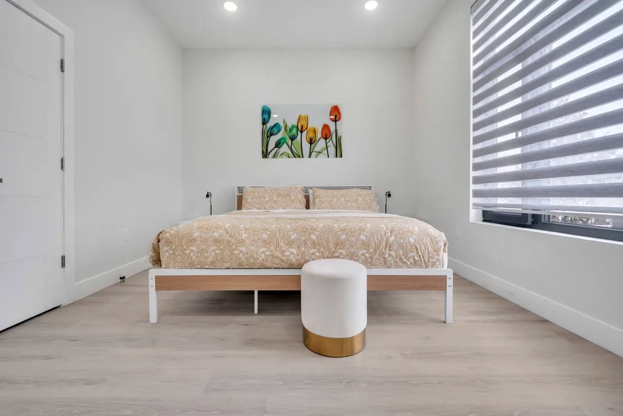 Bedroom with bed, white bench and a window with zebra blinds, Residence 412