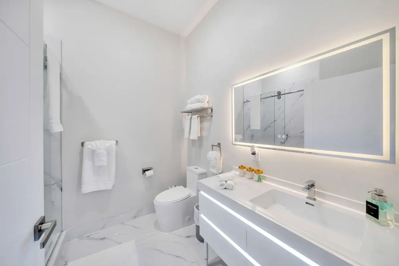 Bathroom with floating vanity, lit mirror and glass shower, Residence 412
