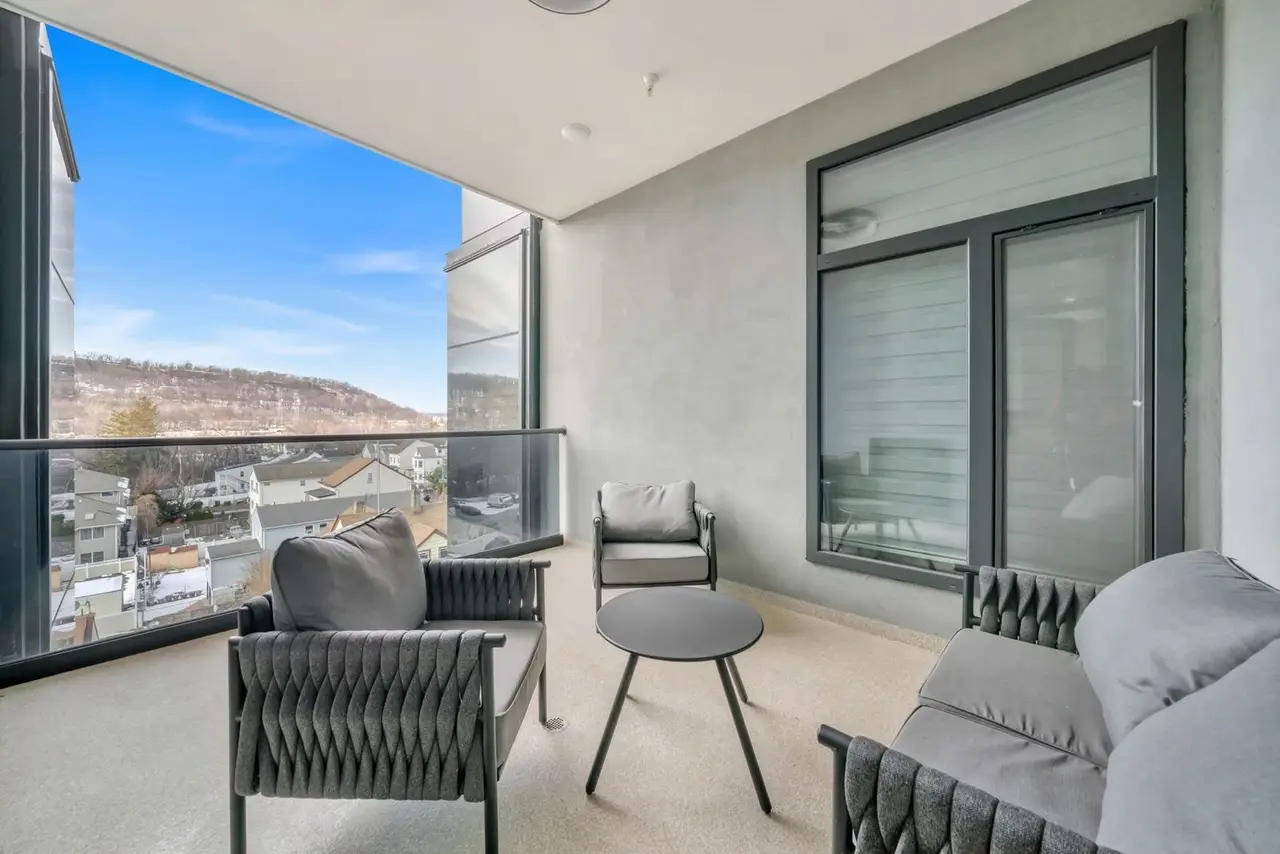 Enclosed terrace with grey woven chairs and a view of hills, Residence 412