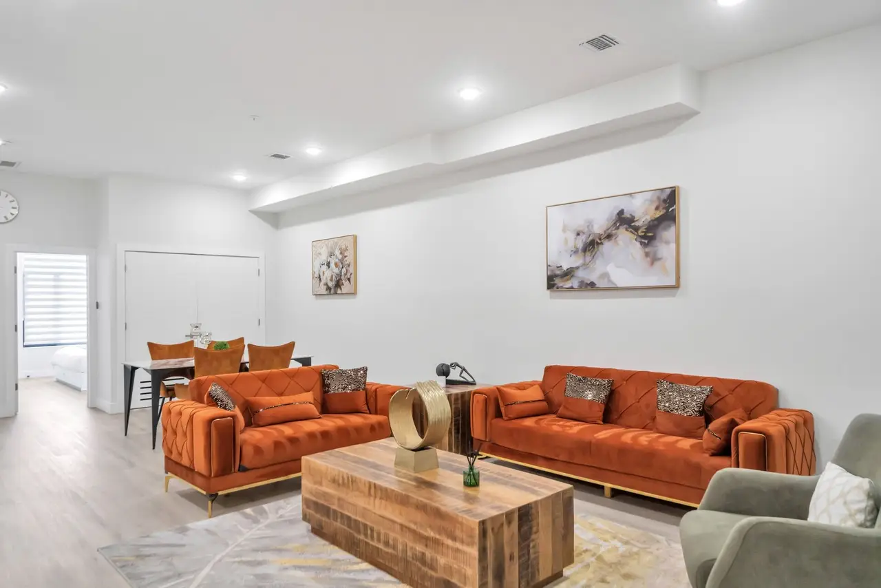 Living room with orange velvet sofas, olive-green armchair and wooden coffee table, Residence 414