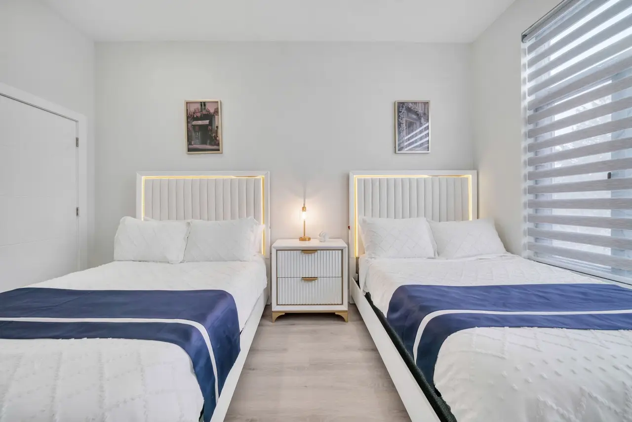 Bedroom with two beds with navy blankets and a nightstand between, Residence 414
