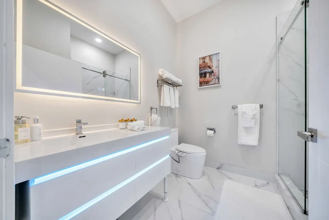 Bathroom with floating vanity with LED strip, lit mirror and glass shower, Residence 414