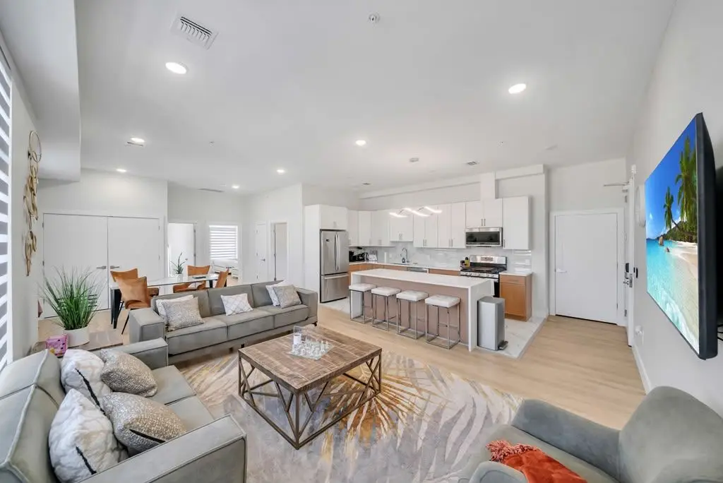 Open living area with sectional, coffee table and TV, Residence 416