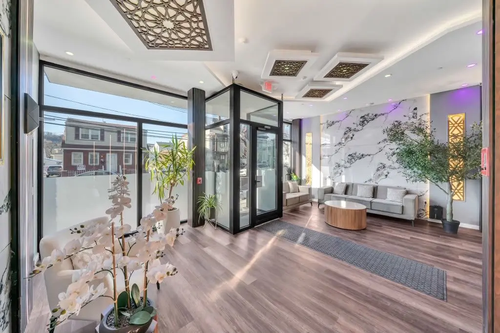 Building lobby with seating area, glass entrance and marble-look feature wall